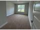 Bedroom showcasing neutral paint and plush carpet, complemented by a large window at 5311 Tuscany Dr, Douglasville, GA 30135