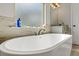 Relax in this luxurious bathroom with granite counters, double sinks, and large soaking tub under a frosted glass window at 125 Atkins Ln, Fayetteville, GA 30215