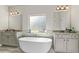 Bright bathroom featuring granite counters, double sinks, a soaking tub, and a large window for natural light at 125 Atkins Ln, Fayetteville, GA 30215