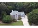 Aerial view of a two-story red brick home with a large, manicured lawn surrounded by lush trees at 1858 De Winton Pl, Lawrenceville, GA 30043