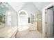 Bright bathroom featuring a whirlpool tub, walk-in shower, double vanity, and a large window at 1858 De Winton Pl, Lawrenceville, GA 30043