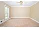 Bright bedroom featuring neutral walls, carpet, ceiling fan, and a window providing natural light at 1858 De Winton Pl, Lawrenceville, GA 30043