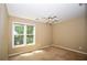Light bedroom with neutral walls, carpet, and a window looking out to green trees at 1858 De Winton Pl, Lawrenceville, GA 30043