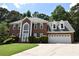 Two-story brick home featuring a well-manicured lawn and an attached two-car garage in a desirable neighborhood at 1858 De Winton Pl, Lawrenceville, GA 30043