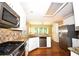 Modern kitchen with stainless steel appliances, granite counters, tile backsplash, and hardwood flooring throughout at 1858 De Winton Pl, Lawrenceville, GA 30043