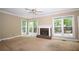 Spacious living room featuring a classic brick fireplace, neutral paint, and large windows overlooking the backyard at 1858 De Winton Pl, Lawrenceville, GA 30043