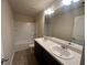 Well-lit bathroom with double sinks, a large mirror, and a shower-tub combination at 2423 Turnbury Glen Walk, Snellville, GA 30078