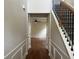 Hallway with rich wood floors, staircase with iron spindles, and wainscoting, offering a grand entrance to the home at 2423 Turnbury Glen Walk, Snellville, GA 30078