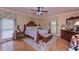 Comfortable bedroom with light wood floors, ceiling fan, and coordinated decorative window coverings at 3743 Johnston Rd, Winston, GA 30187