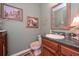 Cozy powder room with decorative mirror, vanity, and light green wall paint at 3743 Johnston Rd, Winston, GA 30187