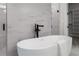 Bathroom featuring a modern tub and separate shower with white marble tile at 89 Batten Board Way, Woodstock, GA 30189