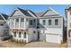 Stunning two-story home featuring white brick, gray siding, a balcony, and a two-car garage at 89 Batten Board Way, Woodstock, GA 30189