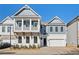 Charming two-story home with white brick, gray siding, a balcony, and a two-car garage at 89 Batten Board Way, Woodstock, GA 30189