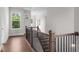 Hallway with hardwood floors and stairs with black wrought iron railing at 89 Batten Board Way, Woodstock, GA 30189