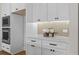 Contemporary kitchen features white cabinets with black hardware and stainless steel appliances at 89 Batten Board Way, Woodstock, GA 30189