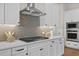 Modern kitchen featuring white cabinets, quartz countertops, tile backsplash, and stainless steel appliances at 89 Batten Board Way, Woodstock, GA 30189