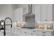 Well-equipped kitchen with stainless steel hood, white cabinets and countertops, and tiled backsplash at 89 Batten Board Way, Woodstock, GA 30189