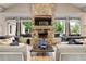 Cozy living room featuring a stone fireplace, large windows, and comfortable seating at 89 Batten Board Way, Woodstock, GA 30189