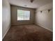 Bedroom featuring carpeted floors, natural light from a window, and storage shelves at 11800 Carriage Park Ln, Johns Creek, GA 30097