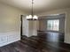 Dining room featuring dark wood-look floors, decorative wainscoting, and modern lighting at 11800 Carriage Park Ln, Johns Creek, GA 30097