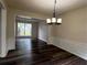 Dining room featuring dark wood-look floors, decorative wainscoting, and modern lighting at 11800 Carriage Park Ln, Johns Creek, GA 30097