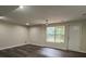 Bright living room with dark floors, a window, and a white entry door at 11800 Carriage Park Ln, Johns Creek, GA 30097