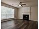 Cozy living room with a fireplace, large window, ceiling fan, and modern flooring at 11800 Carriage Park Ln, Johns Creek, GA 30097