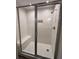 Modern tiled shower with glass doors, a built-in seat, and stylish hexagon-tiled floor at 11800 Carriage Park Ln, Johns Creek, GA 30097