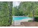 Community pool surrounded by lush trees, tables, and lounge chairs at 1160 Newpark View Pl # 8, Mableton, GA 30126