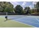 Community tennis courts with blue and green surfacing and green trees at 1160 Newpark View Pl # 8, Mableton, GA 30126