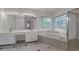 Elegant bathroom with soaking tub surrounded by decorative windows and double sink vanity at 140 Heritage Ct, Fayetteville, GA 30214
