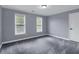 Spacious bedroom with soft carpet, ample lighting, and two large windows at 140 Heritage Ct, Fayetteville, GA 30214