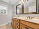 Bathroom includes a double sink vanity with wooden cabinets and framed mirrors at 3843 Dragon Fly Ln, Loganville, GA 30052
