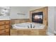 Close up of a bathroom featuring a fireplace over the jetted tub and tile surround at 3843 Dragon Fly Ln, Loganville, GA 30052