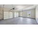 Spacious three car garage with white doors and automatic door openers and two large windows at 3843 Dragon Fly Ln, Loganville, GA 30052
