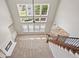 Bright living room with fireplace, built-in shelving, large windows, and staircase at 3843 Dragon Fly Ln, Loganville, GA 30052
