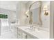 Bathroom featuring marble counters, white cabinets, sconces, and a large framed mirror at 2466 Brookhaven Ne Pl, Brookhaven, GA 30319