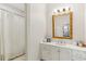 Bright bathroom with a shower, white vanity, and a large mirror with decorative gold frame at 2466 Brookhaven Ne Pl, Brookhaven, GA 30319