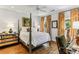 Bright bedroom featuring a four-poster bed, hardwood floors, and vibrant orange floral curtains at 2466 Brookhaven Ne Pl, Brookhaven, GA 30319