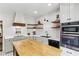 Charming kitchen with white cabinetry, stainless steel appliances, butcher block island, and open shelving at 2466 Brookhaven Ne Pl, Brookhaven, GA 30319