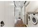Bright laundry room with sliding barn doors, stacked washer and dryer, and a colorful rug at 2466 Brookhaven Ne Pl, Brookhaven, GA 30319