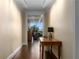 Inviting hallway featuring a console table, hardwood floors, and a glimpse into the bright living area at 2660 Peachtree Nw Rd # 13F, Atlanta, GA 30305