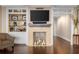 Cozy living room with a fireplace, built-in shelves, and hardwood floors, creating a warm atmosphere at 2660 Peachtree Nw Rd # 13F, Atlanta, GA 30305