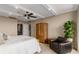 Bright main bedroom featuring a beamed ceiling, soft neutral paint, and a cozy seating area with a leather chair at 2660 Peachtree Nw Rd # 13F, Atlanta, GA 30305