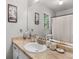 Clean bathroom with a marble counter, decorative accents, and a window view at 1000 Coan Dr, Locust Grove, GA 30248