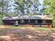 Back exterior view of home featuring a porch and wooded lot at 1000 Coan Dr, Locust Grove, GA 30248