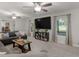 Bright living room boasts a large TV, windows, neutral carpet, and comfortable seating at 1000 Coan Dr, Locust Grove, GA 30248