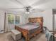 Comfortable main bedroom featuring a rustic wooden bed frame, footlocker, and open window view at 1000 Coan Dr, Locust Grove, GA 30248