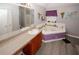 Bathroom featuring corner tub with jets, decorative accents, and vanity area at 1964 Cutters Mill Way, Lithonia, GA 30058
