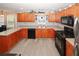 Functional kitchen features warm wood cabinets, stainless appliances, and durable countertops at 1964 Cutters Mill Way, Lithonia, GA 30058